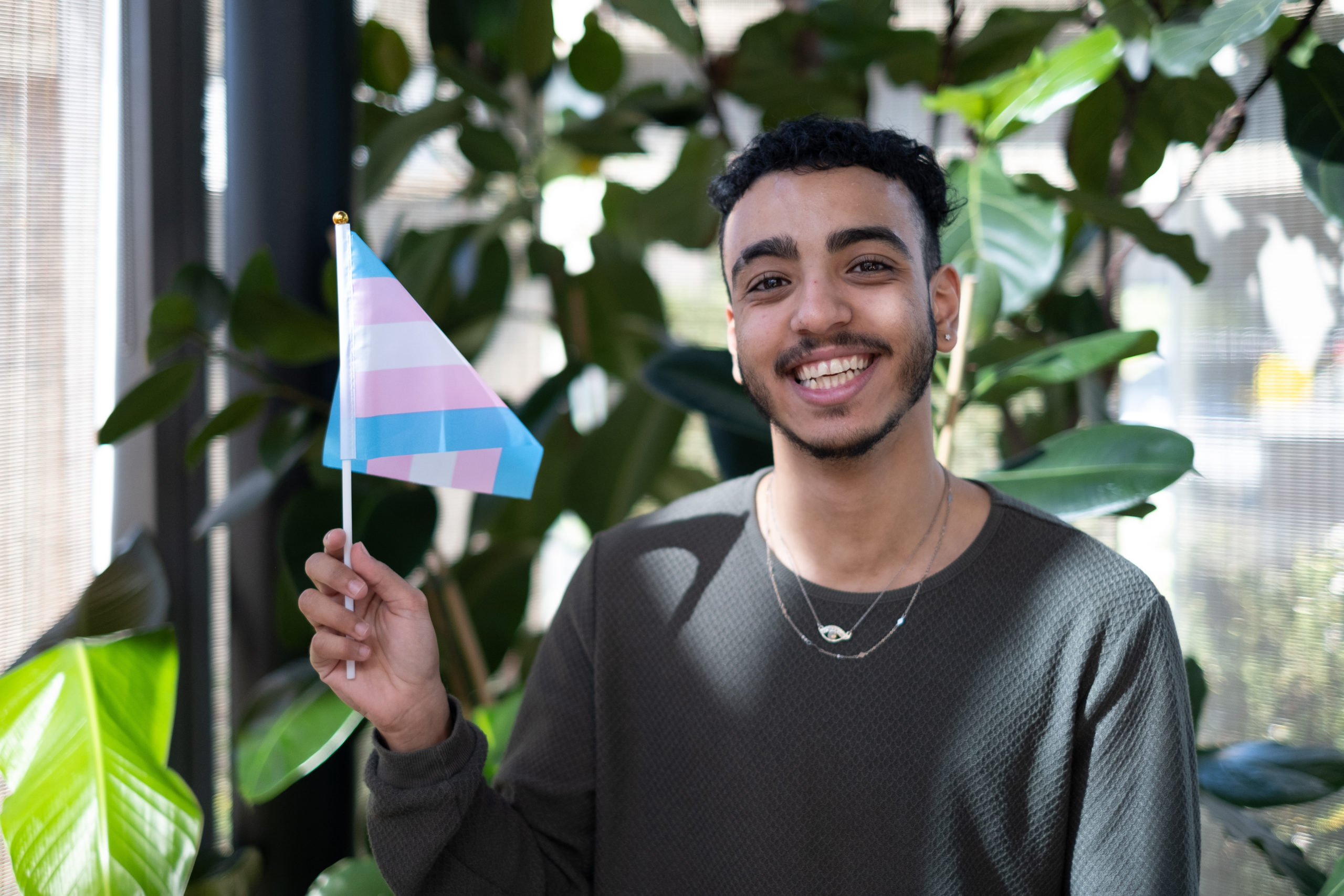A Just Like Us volunteer holding a trans Pride flag