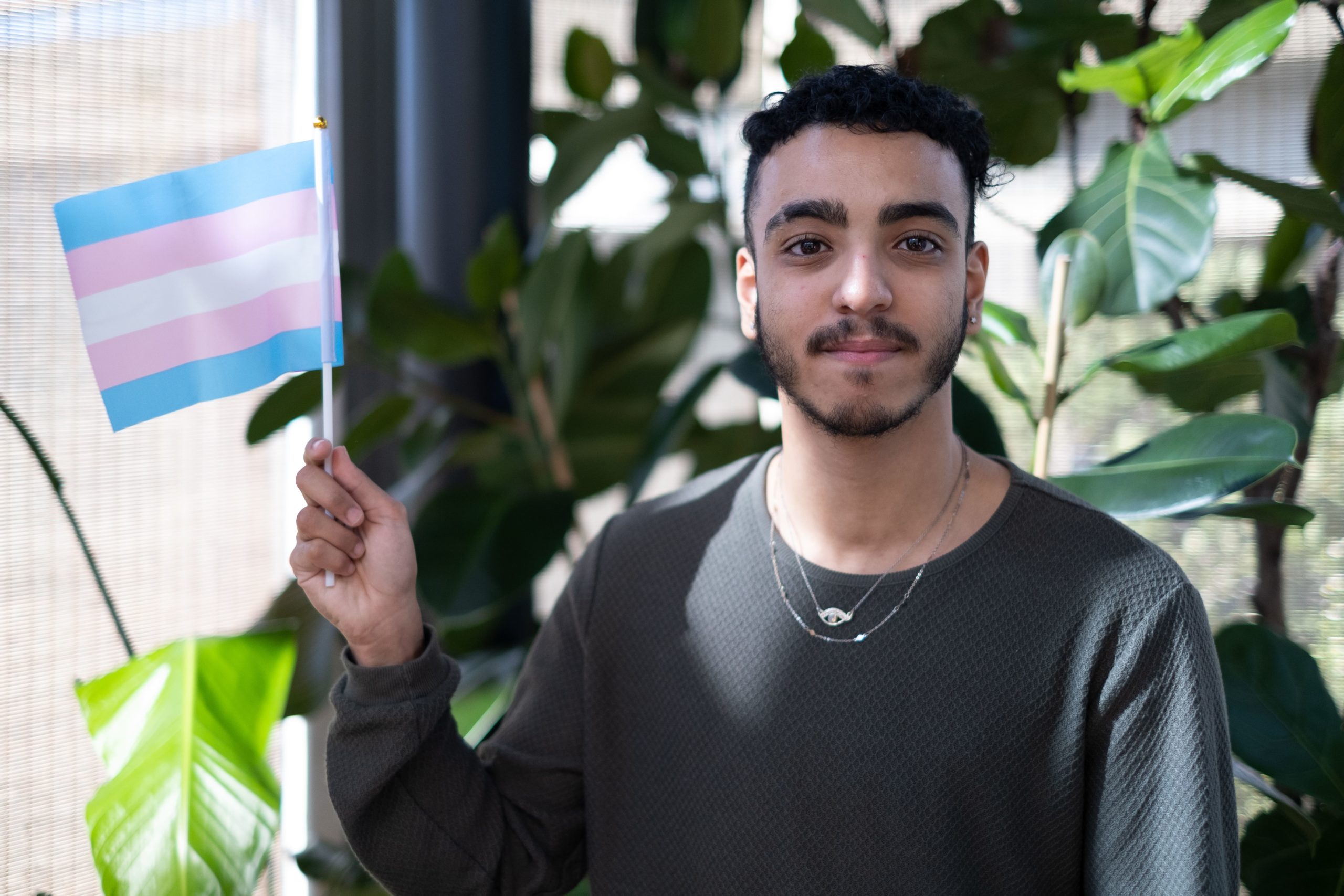 Isaac, a Just Like Us ambassador, waving a transgender flag
