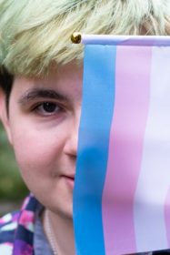 Roan, a Just Like Us ambassador, holding up a transgender flag