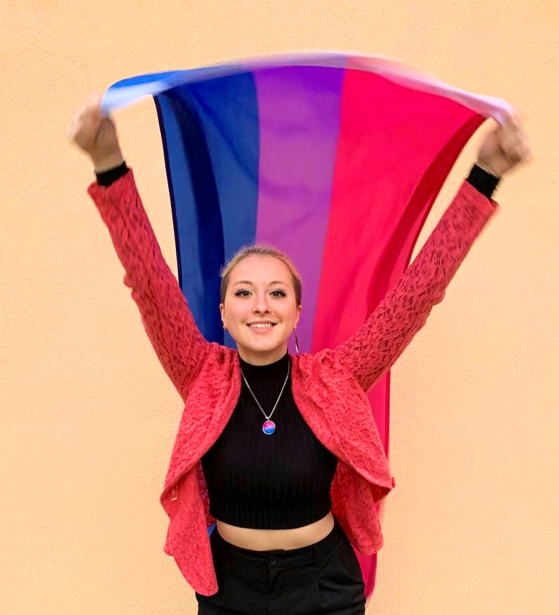 Lili holding the bisexual Pride flag