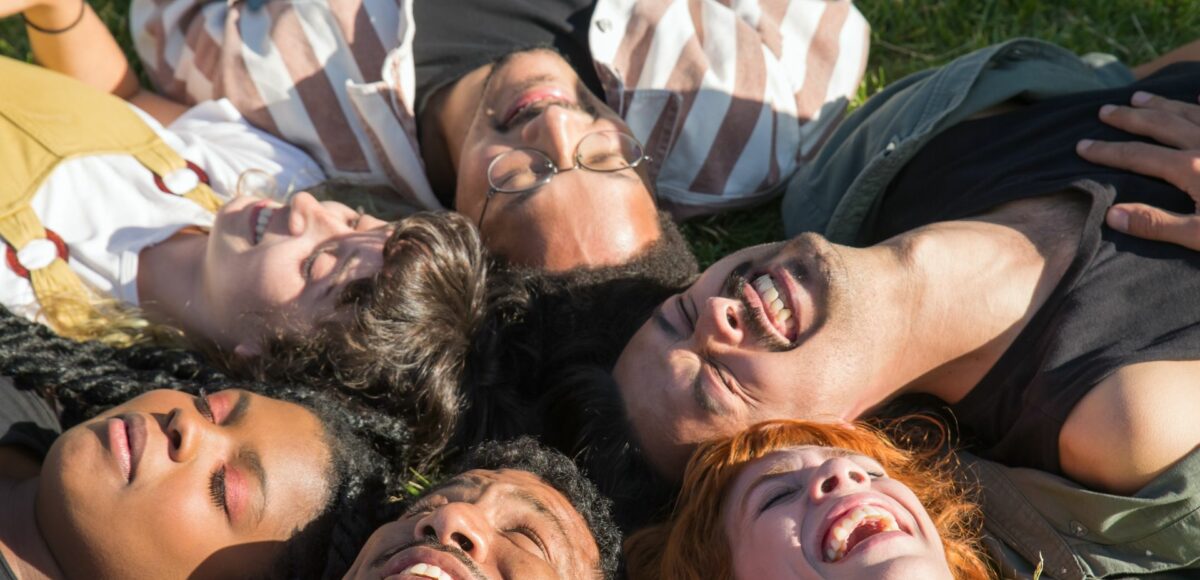 A group of young adults lying on the grass