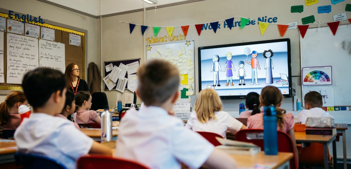 School pupils watch a video in a classroom decorated with rainbow bunting for School Diversity Week